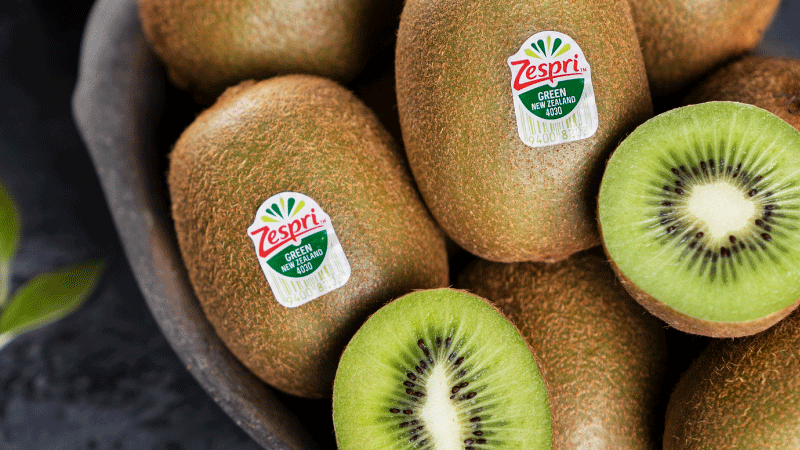 Close up of whole and cut Green kiwifruit in a bowl.